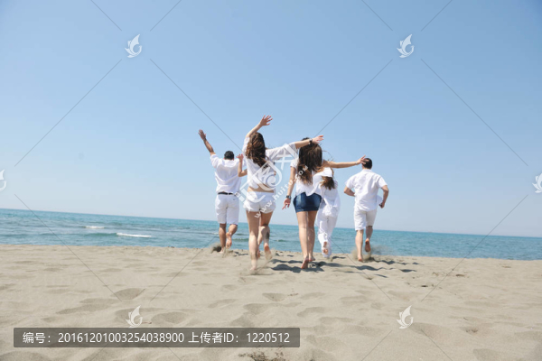 快樂人團體在海灘上玩樂和跑步
