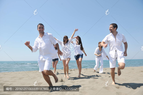 快樂(lè)人團(tuán)體在海灘上玩樂(lè)和跑步
