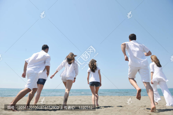 快樂(lè)人團(tuán)體在海灘上玩樂(lè)和跑步