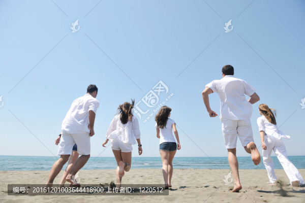 快樂(lè)人團(tuán)體在海灘上玩樂(lè)和跑步