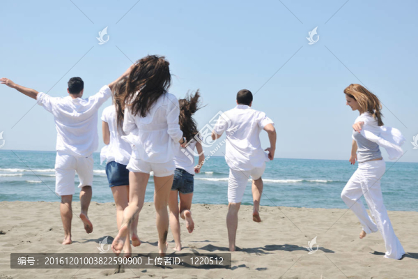 快樂人團體在海灘上玩樂和跑步