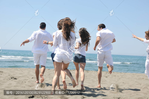 快樂人團體在海灘上玩樂和跑步
