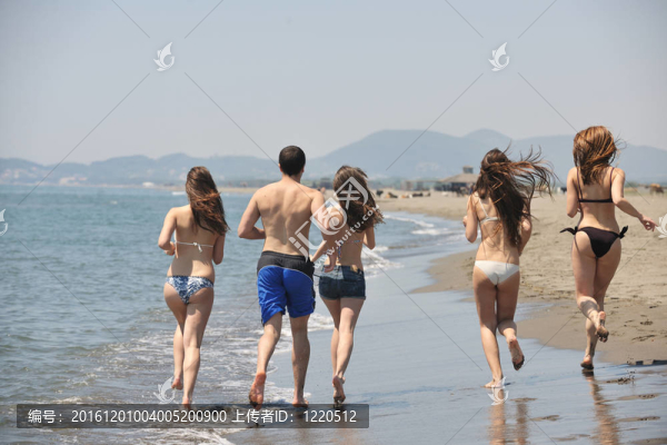 快樂人團(tuán)體在海灘上玩樂和跑步