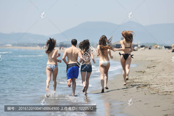 快樂人團體在海灘上玩樂和跑步