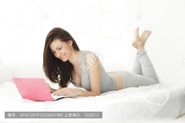 年輕的女孩微笑著在她的電腦