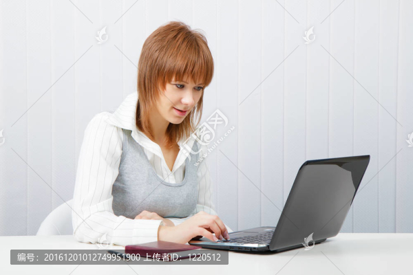 漂亮的女孩在辦公室里帶筆記本電腦