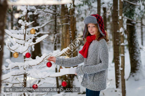 可愛(ài)的女孩在白雪皚皚的森林裝飾圣誕樹(shù)