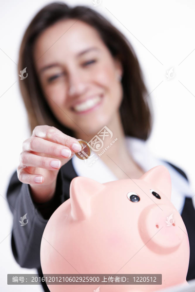 年輕女子把錢放進存錢罐