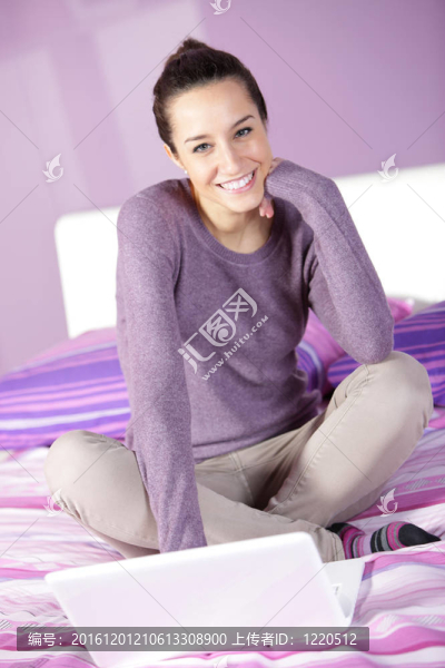 床上的女人在使用筆記本電腦的時(shí)候