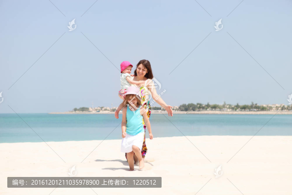 母親和她的兩個女兒在海灘上