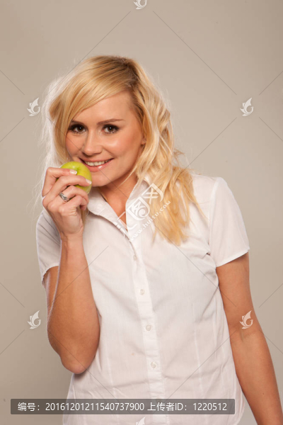 微笑的女人吃一個蘋果