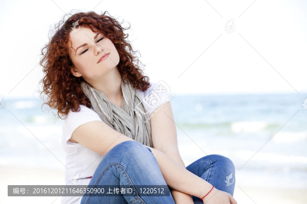 有趣的少女坐在沙灘上的沙灘上。