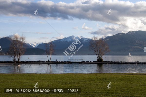 草的海灘和雪山在阿訥西湖