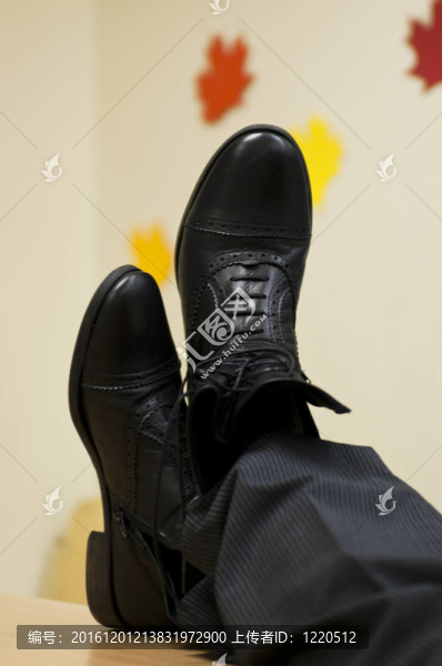 黑色皮鞋交叉在桌上