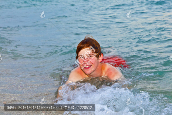 躺在沙灘上的男孩享受著大海的沖浪