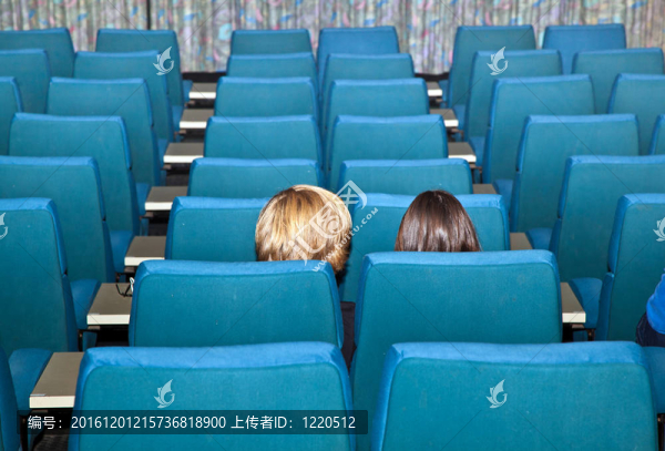 坐在電影院里等待電影的青少年