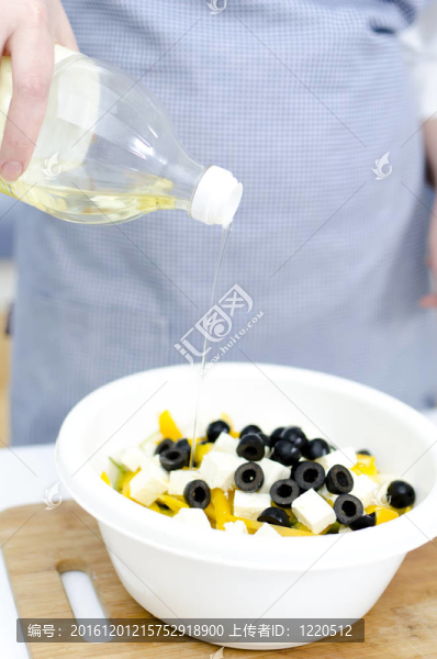 希臘沙拉的制備：油倒在希臘沙拉