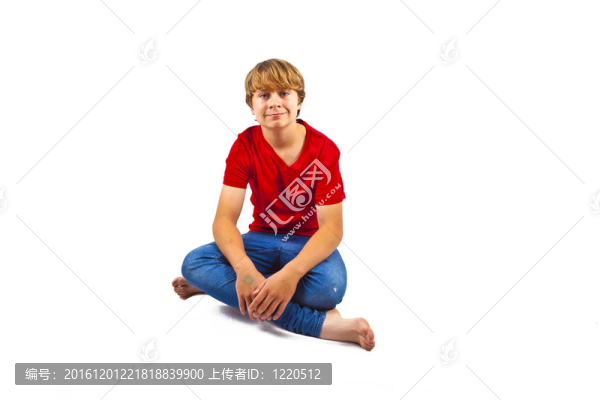 聰明的男孩穿著紅色的襯衫坐在地板上