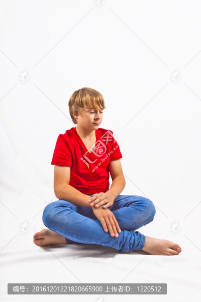 聰明的男孩穿著紅色的襯衫坐在地板上