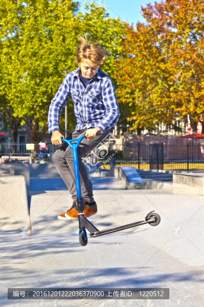 男孩在滑板公園用滑板車(chē)跳