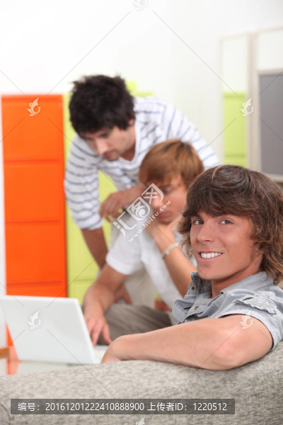 小伙子們在家里帶著一臺筆記本電腦