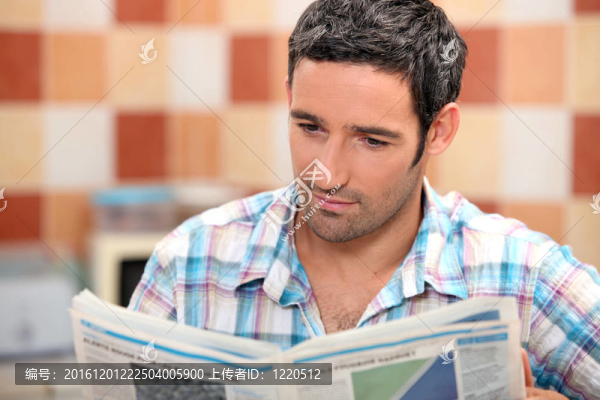 男人在廚房里讀雜志