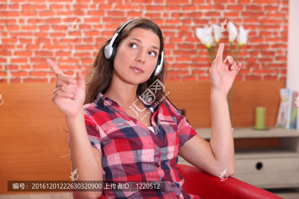 年輕的女人在家里聽音樂