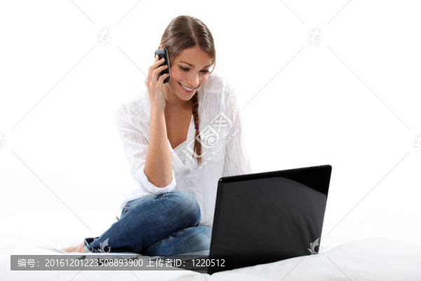 女人在電話里看著她的筆記本電腦