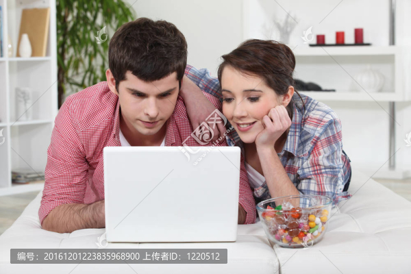 年輕夫婦在他們的筆記本電腦上看電影