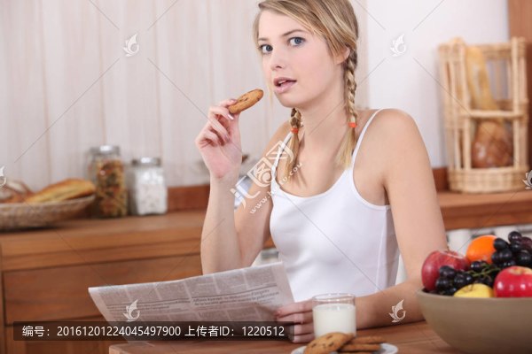婦女吃早餐和閱讀報(bào)紙