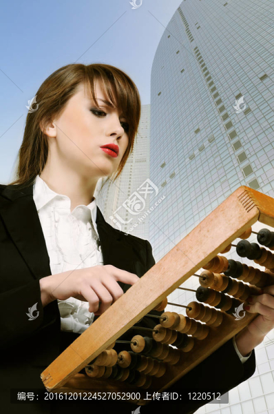 年輕漂亮的女商人手里拿著木制的算盤。