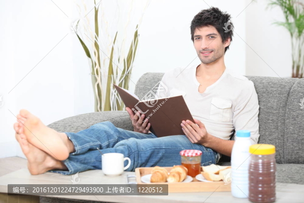 男子在早餐時讀一本書