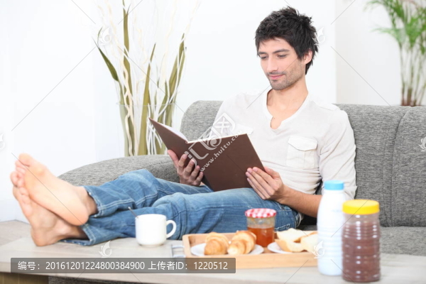 男子在沙發(fā)放松與專(zhuān)輯在早餐時(shí)間