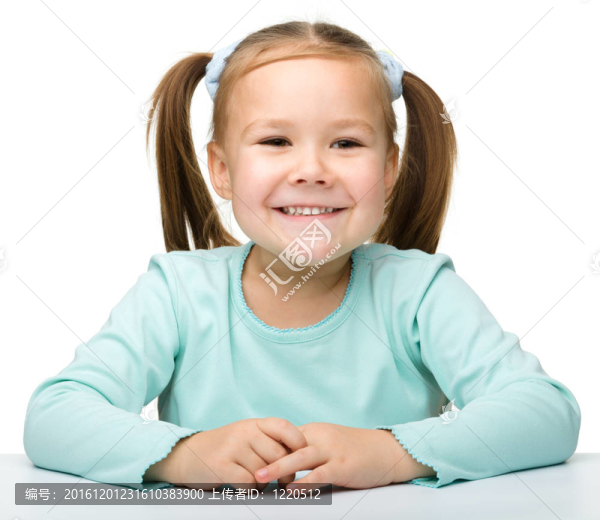 快樂的小女孩正坐在桌子旁
