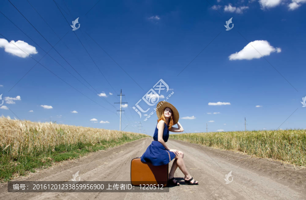 鄉(xiāng)村路上帶著手提箱的寂寞女孩。