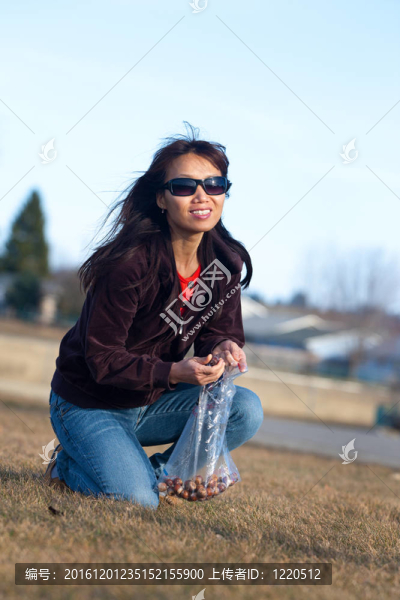 女人撿橡子。