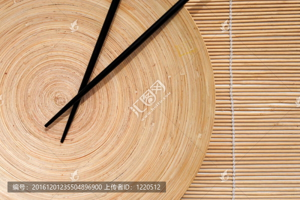 在木制的圓形盤竹餐墊背景日本筷子
