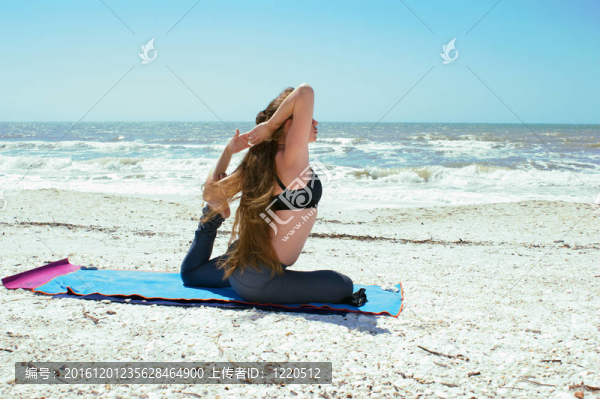 年輕的女人做瑜伽運(yùn)動對Kapotasana的海灘或鴿子