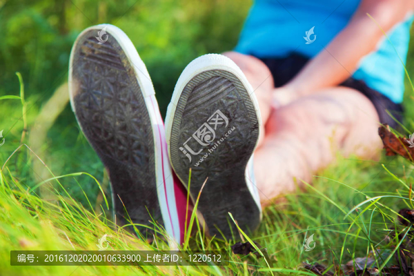 粉紅的運(yùn)動(dòng)鞋在草地上的女孩的腿上