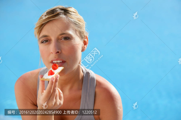 婦女吃烤片與草莓片