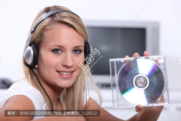 一個金發(fā)女子聽音樂和顯示光盤