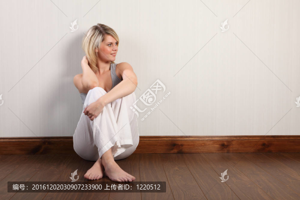 漂亮的金發(fā)女郎坐在地板上