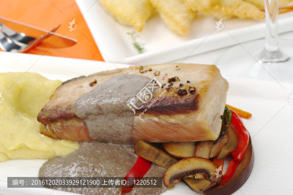 主菜：用土豆泥金槍魚；具有開胃白盤肉汁和蔬菜；背景中的餐具和玻璃（選擇性聚焦；對魚和一些蔬菜的前面部