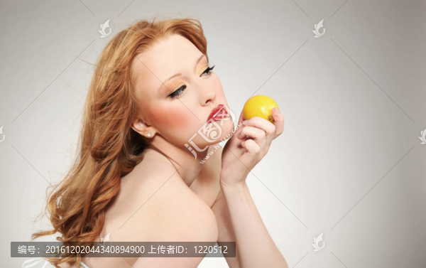 年輕漂亮的女人拿著一個(gè)檸檬