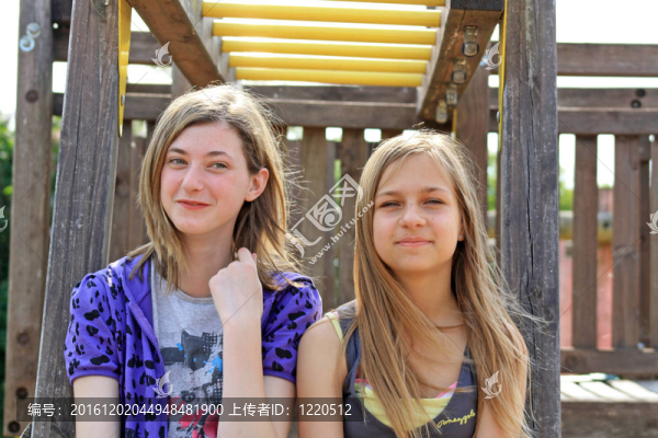 兩個(gè)十幾歲的女孩坐在長(zhǎng)椅上