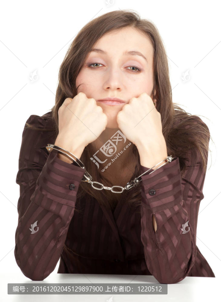 坐在棕色上衣的年輕女子帶著手銬的雙手