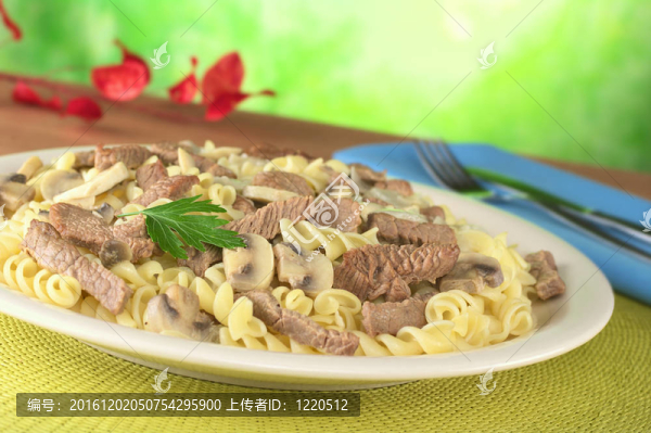 在奶油醬牛肉條送達(dá)意大利面食白蘑菇和洋蔥，配上香菜葉（選擇性聚焦；上香菜葉和周邊重點(diǎn)）