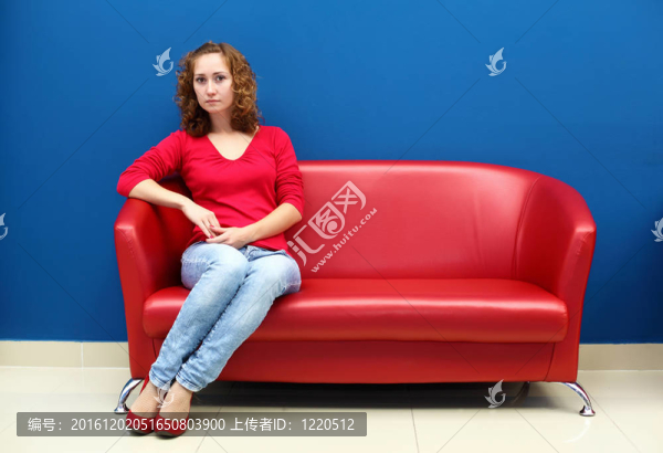 坐在紅色沙發(fā)上的年輕女人