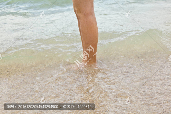 沿著海灘跑步的男孩的腳