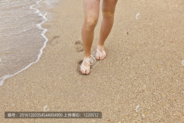 沿著海灘跑步的男孩的腳